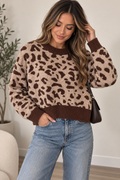 A woman wearing a brown and beige leopard print fuzzy knit sweater with ribbed cuffs and hem, paired with light blue jeans and carrying a dark brown shoulder bag.