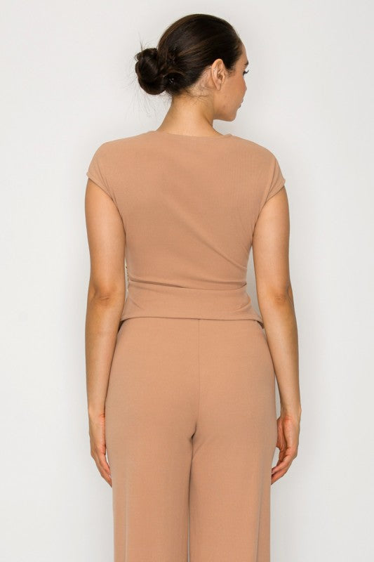 Woman wearing a beige jumpsuit against a white background