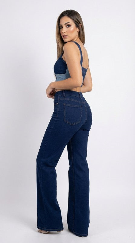 Woman wearing dark blue flared jeans on a white background