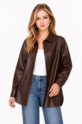 Model wearing a dark brown faux-leather button-up shacket over a white top and blue jeans.
