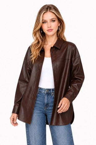 Model wearing a dark brown faux-leather button-up shacket over a white top and blue jeans.