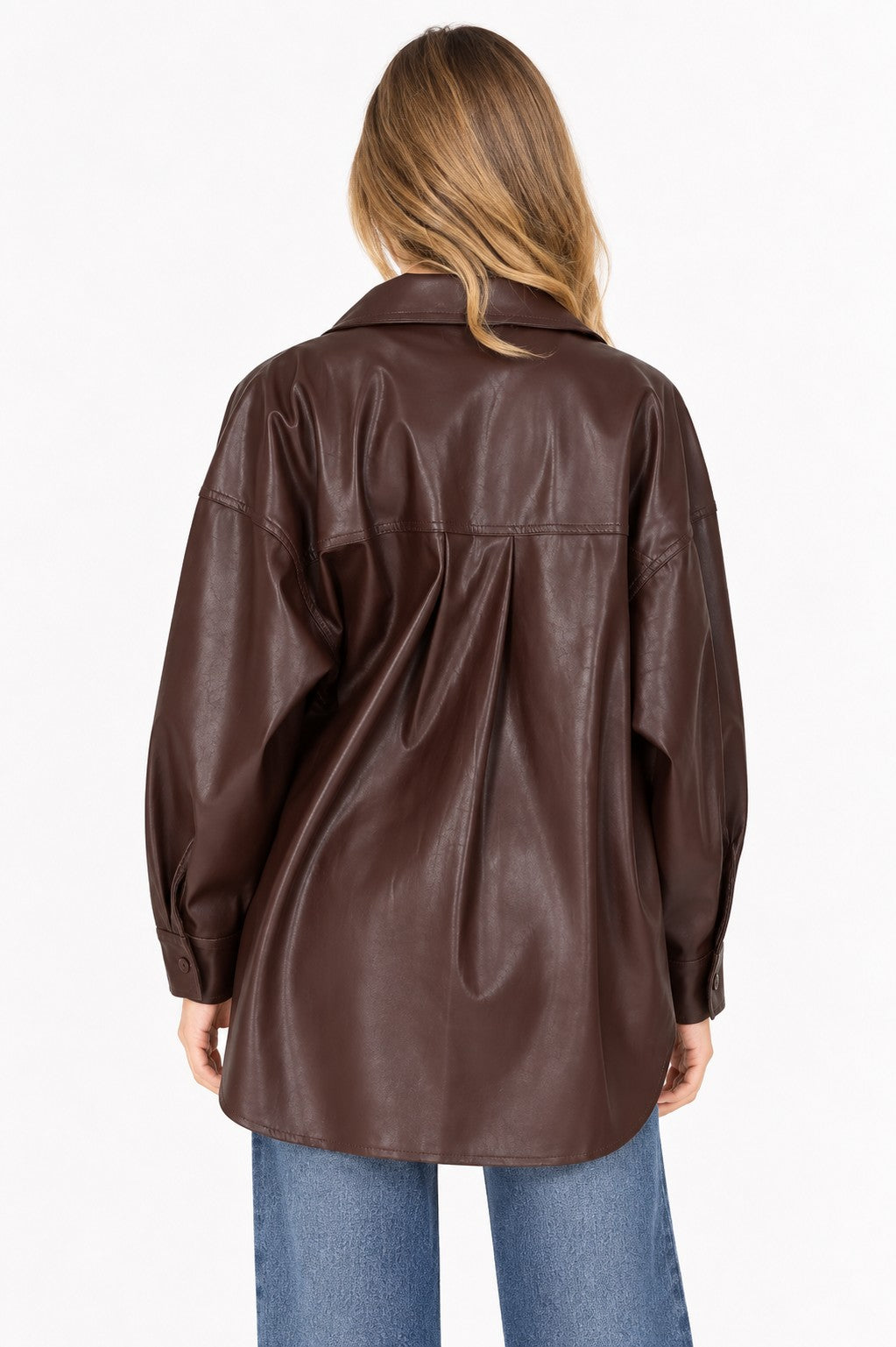 Model wearing a dark brown faux-leather button-up shacket over a white top and blue jeans.