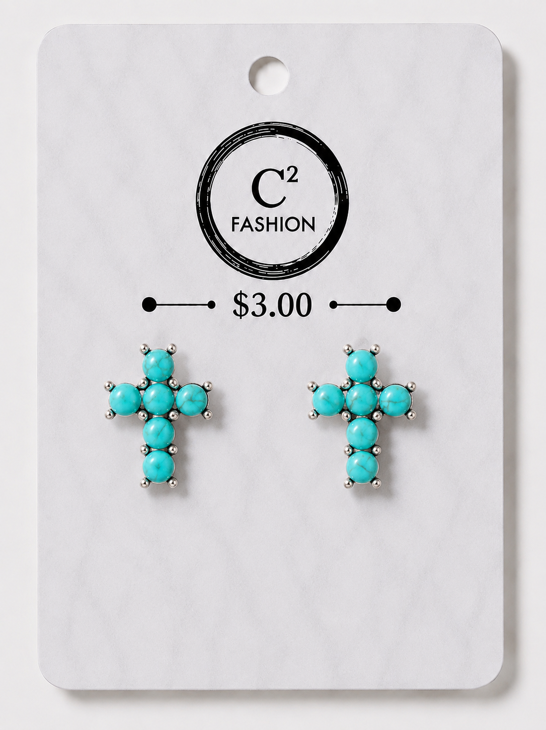 A pair of turquoise cross stud earrings with silver-toned prong settings, displayed on a white marble-style retail card with the C² FASHION logo and a $3.00 price mark.