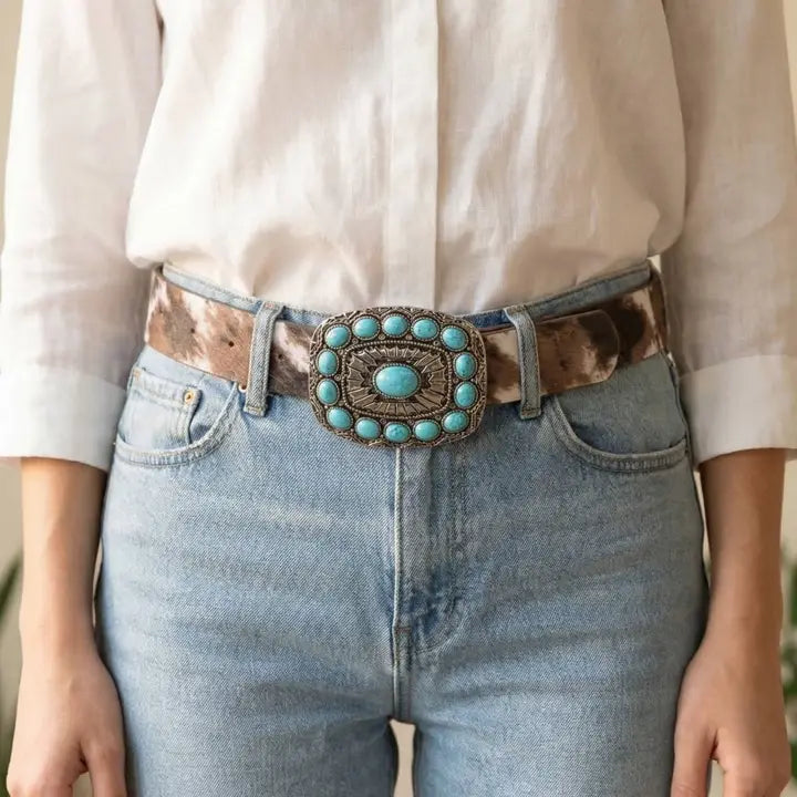 Person wearing a belt with a turquoise buckle and brown leather strap.