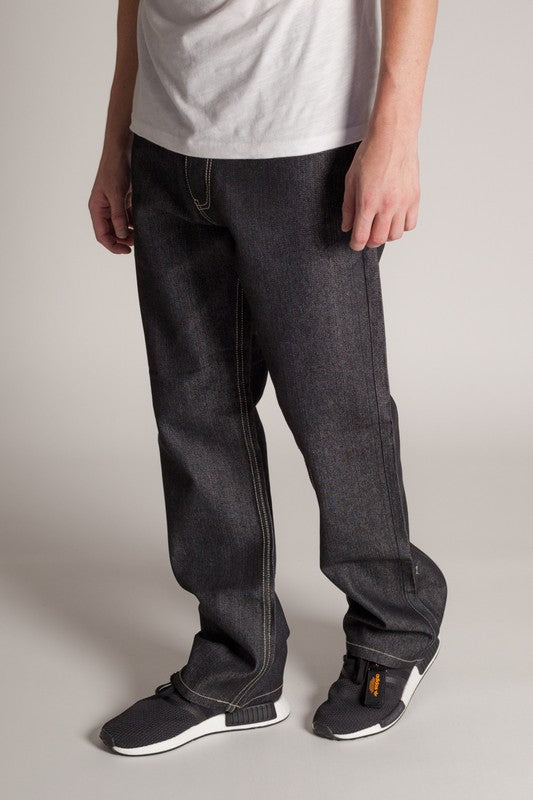Men’s dark wash straight-leg jeans worn with a white t-shirt and black-and-white sneakers on a neutral background.