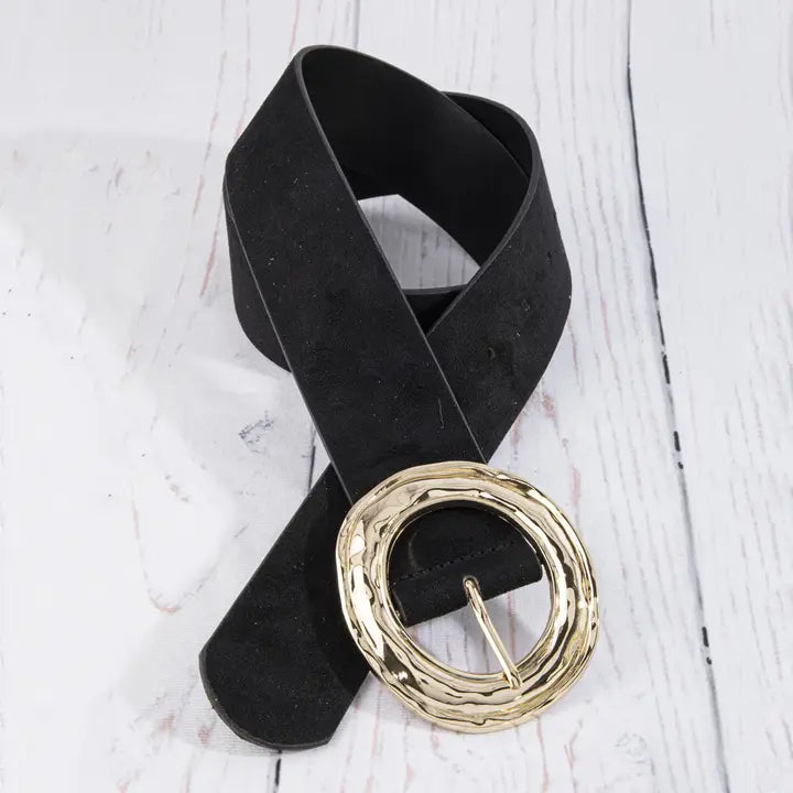 A black wide belt with a chunky, textured gold-tone buckle, displayed on a white wood-plank background.