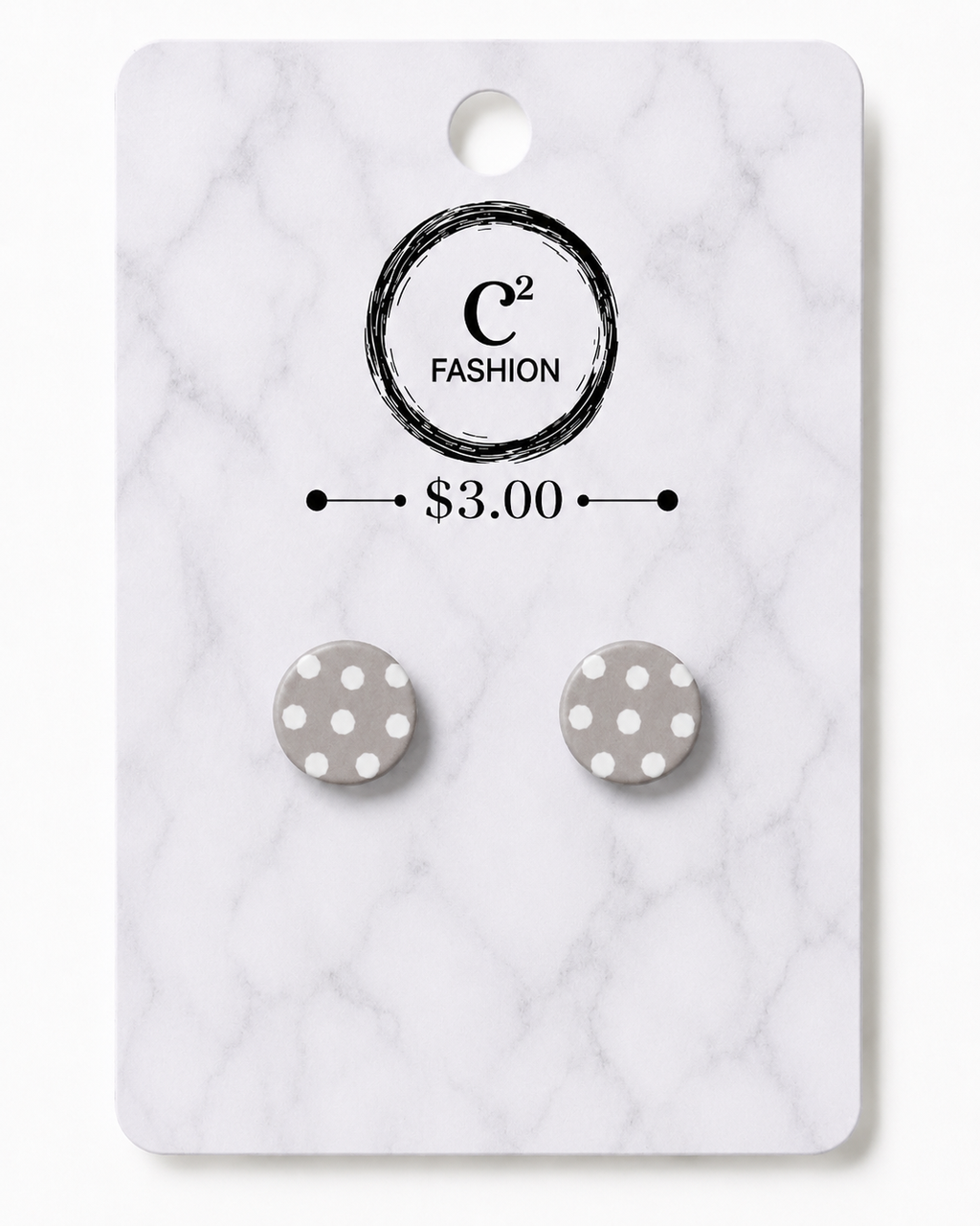 A pair of round gray and white polka dot stud earrings displayed on a white marble-patterned retail card with the brand name C2 FASHION and a $3.00 price printed on it.