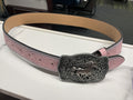 A pink tooled leather belt with a large engraved silver-toned buckle featuring a horse design, displayed on a white surface.