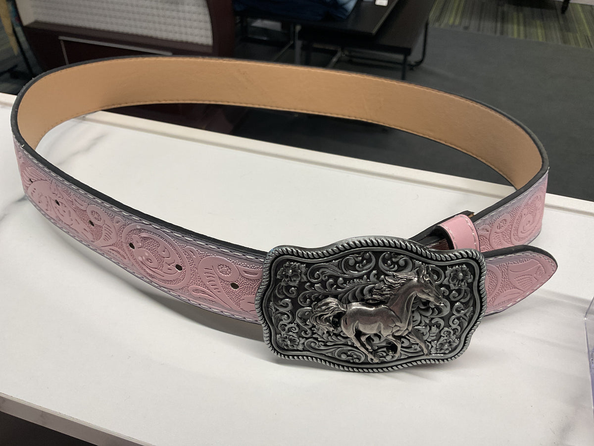 A pink tooled leather belt with a large engraved silver-toned buckle featuring a horse design, displayed on a white surface.