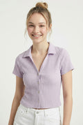 Woman wearing a purple striped shirt against a white background