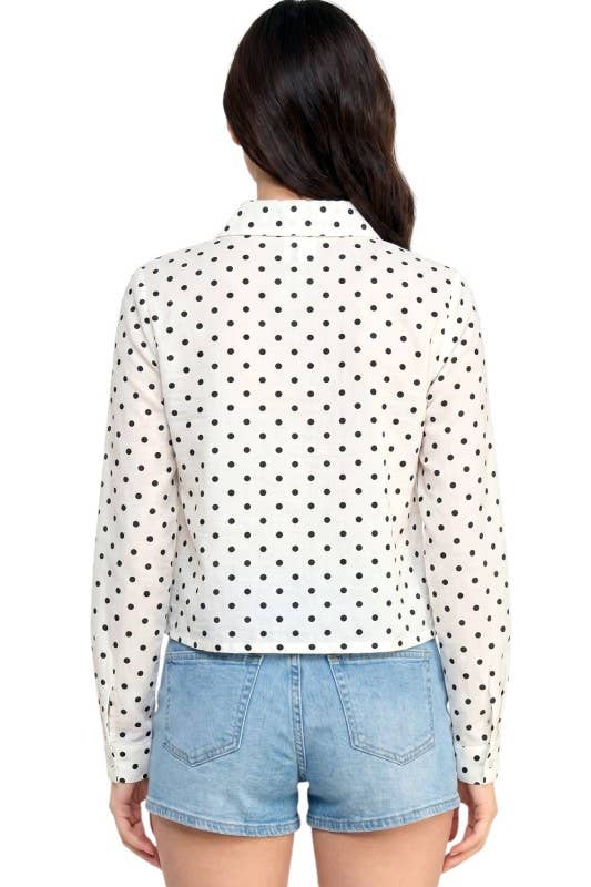 Person wearing a polka dot shirt and denim shorts on a white background