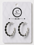 A pair of silver-tone hoop earrings with black onex rhinestones, displayed on a white marble-patterned retail card with the brand name C² FASHION and a $5.00 price printed on it.