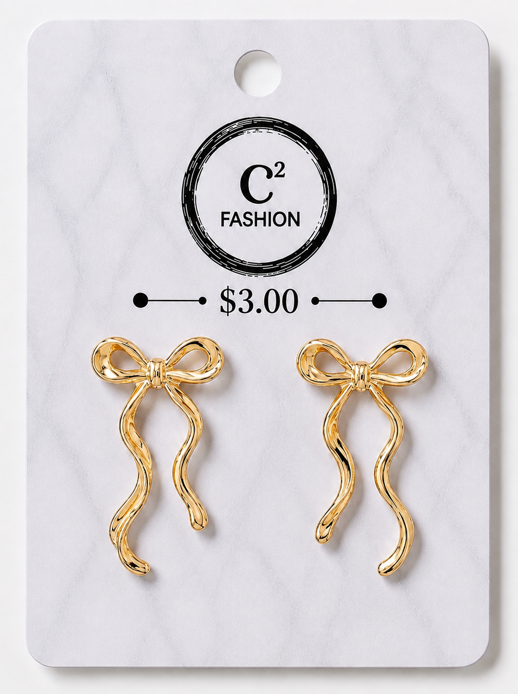 A pair of gold bow-shaped earrings displayed on a white marble-style retail card with the brand name C² FASHION and a price of $3.00 printed on it.