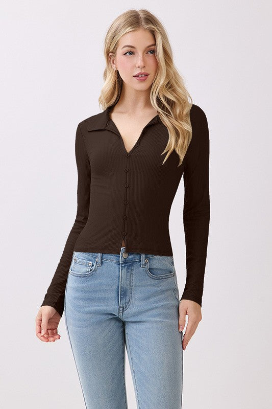 Woman wearing a brown long-sleeve top and blue jeans on a white background