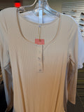 Beige ribbed shirt with buttons on a hanger in a store setting