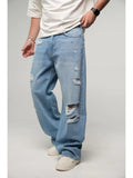 Person wearing light blue distressed jeans on a plain background
