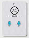 A pair of lightning bolt stud earrings in bright turquoise blue with silver-tone borders, displayed on a white marble-style card labeled C² FASHION and $3.00.