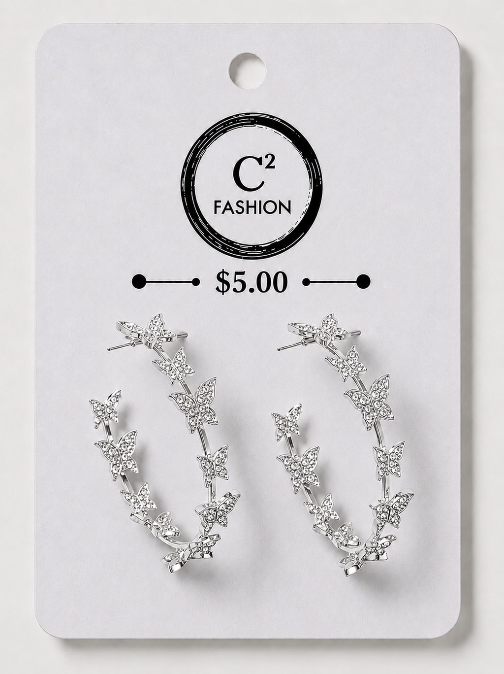 A pair of silver crescent-shaped hoop earrings decorated with small star and leaf motifs, displayed on a white C² FASHION brand card labeled $5.00.
