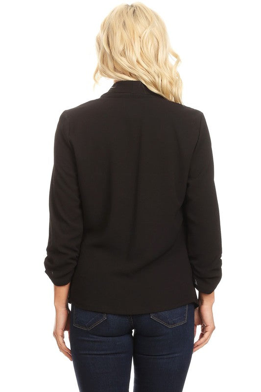 Person wearing a black blazer and blue jeans on a white background