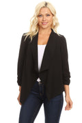Woman wearing a black blazer over a white top and blue jeans on a white background