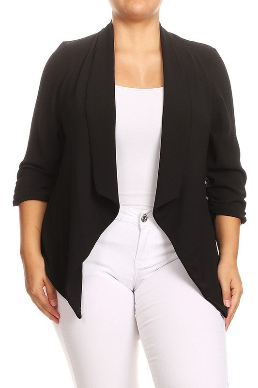 Person wearing a black open-front cardigan over a white top and pants on a white background
