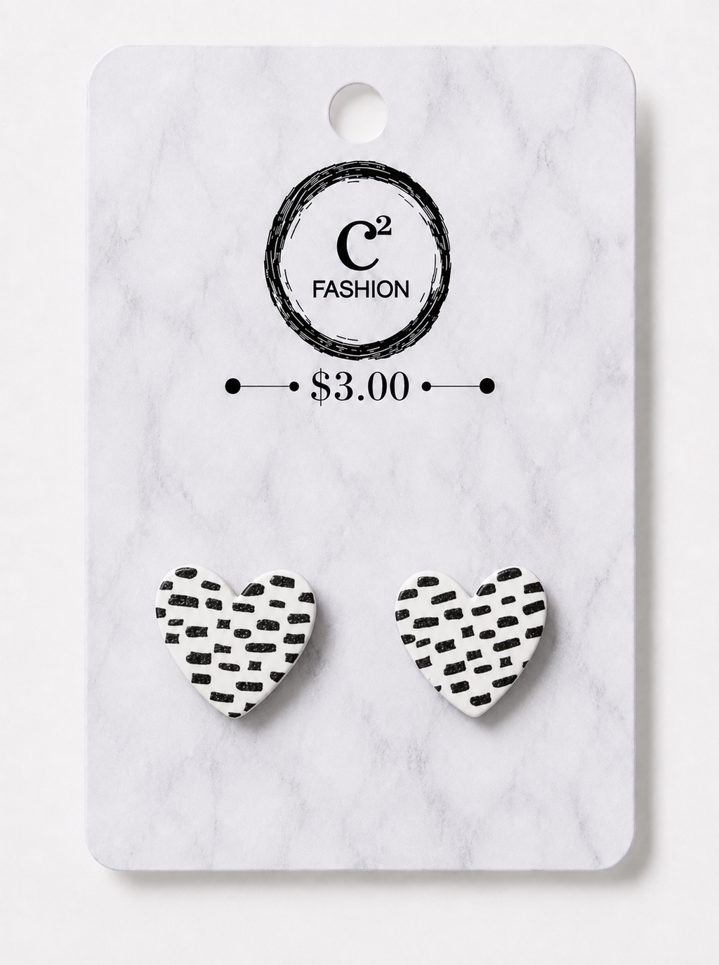 A pair of heart-shaped stud earrings with a black hand-drawn pattern on a white background, displayed on a white marble backing card with the brand logo 'C2 FASHION' and a price of '$3.00'.