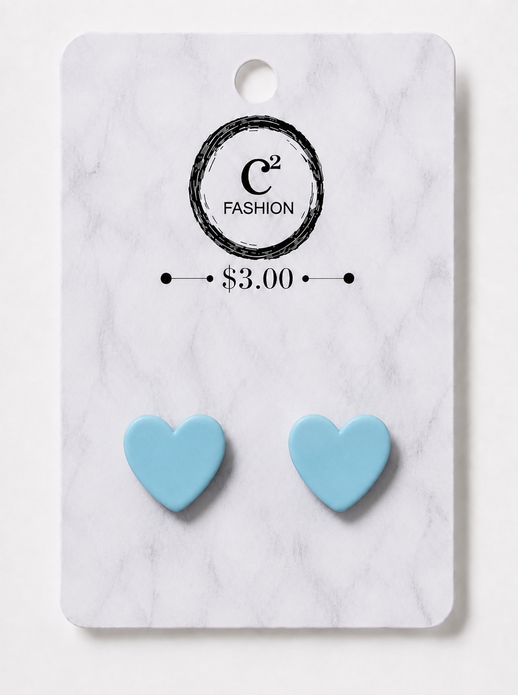 A pair of light blue heart-shaped stud earrings displayed on a white marble-patterned retail card with the C2 FASHION logo and $3.00 price printed on it.