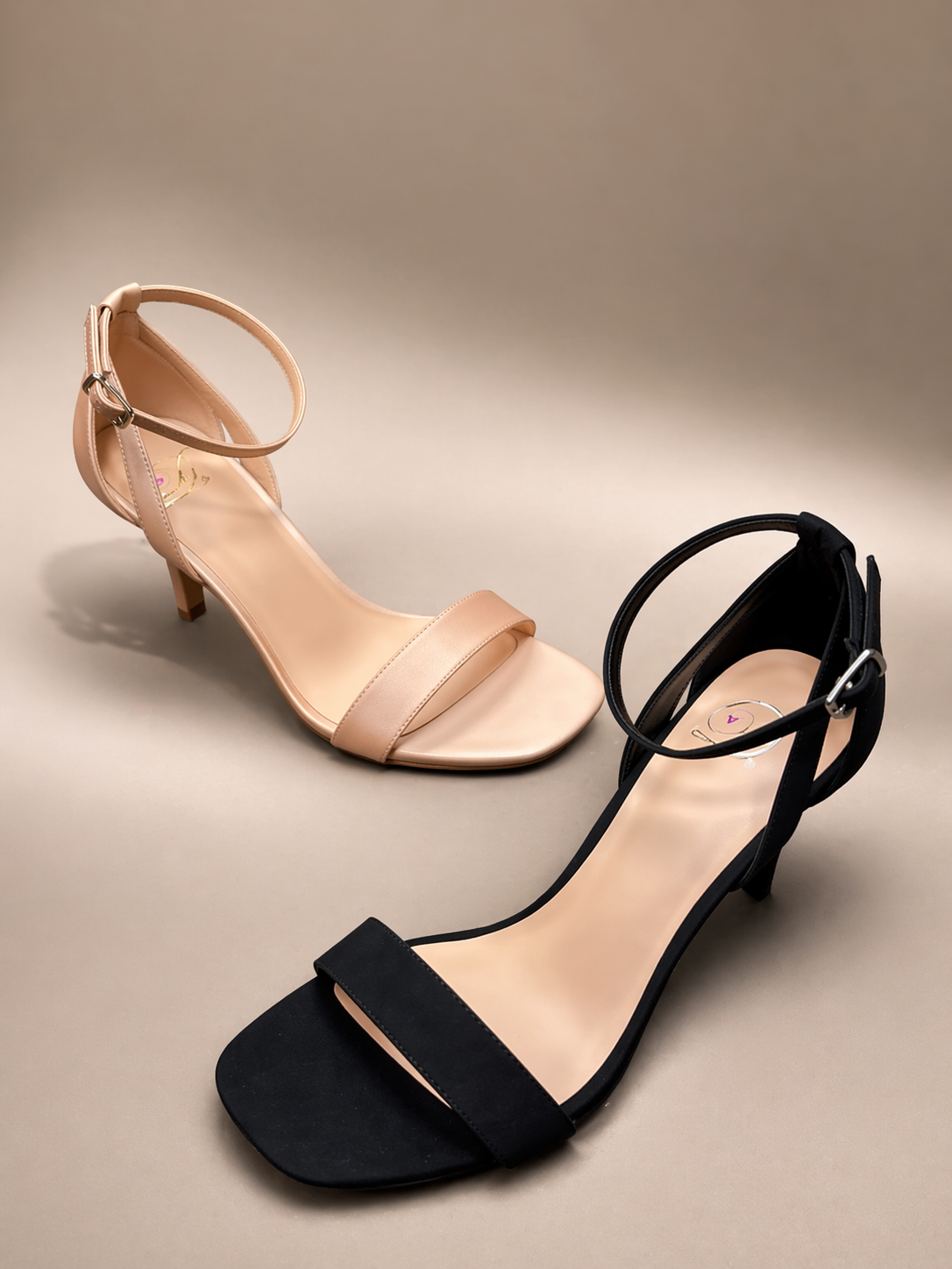 Black and beige high-heeled sandals on a beige background