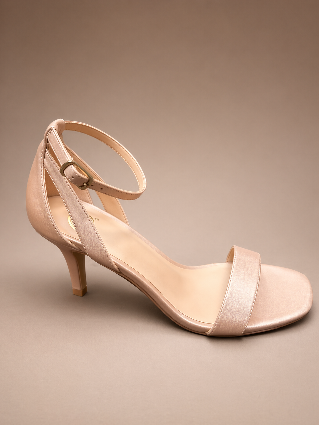 Beige sandal with a strap on a beige background
