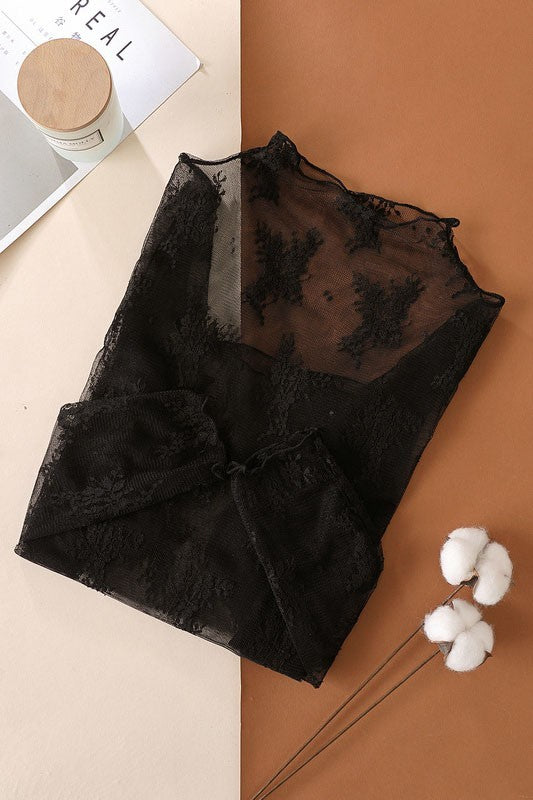 Black lace top on a split beige and brown background with a white flower.