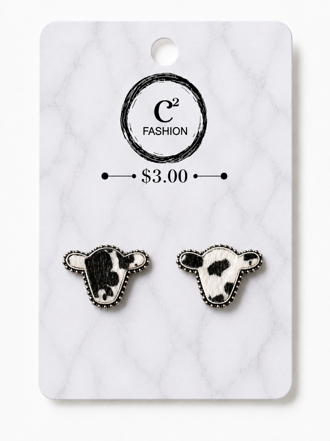 A pair of cow head stud earrings displayed on a white marble-style backing card. The card shows the brand name 'C2 FASHION' and a price of '$3.