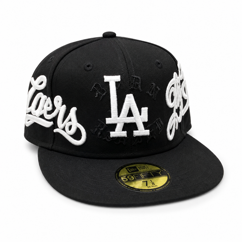 Black New Era 59FIFTY fitted cap with raised white “LA” logo and “Los Angeles” script embroidery around the crown, flat brim, size 7 1/8, shown on a clean white background.