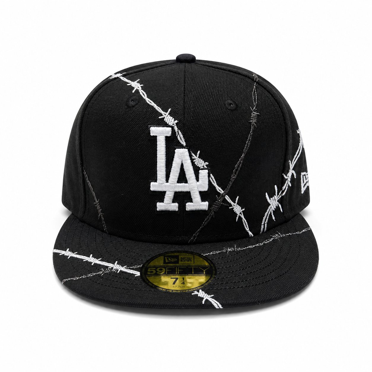 Black fitted cap with white LA logo and barbed wire embroidery design, flat brim, and 59FIFTY sticker on a clean white background