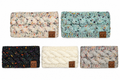 Five chunky cable-knit winter headbands displayed on a white background in ivory speckled, sage green speckled, black multicolor speckled, cream, and gray speckled. Each headband features a braided knit design and a small brown C.C logo patch.