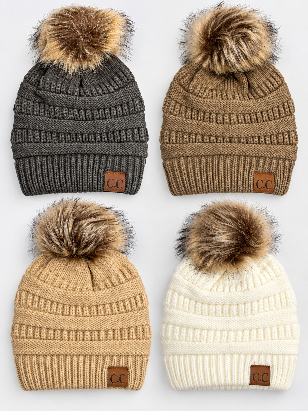 Four ribbed knit pom-pom beanies arranged in a 2x2 grid on a light gray background. The top-left beanie is charcoal gray, the top-right is taupe brown, the bottom-left is tan, and the bottom-right is cream.
