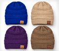 Four ribbed knit beanie hats arranged in a 2x2 grid on a light gray background, shown in blue, tan, purple, and brown. Each beanie has a small brown leather patch on the front cuff with the letters 'CC' in white.