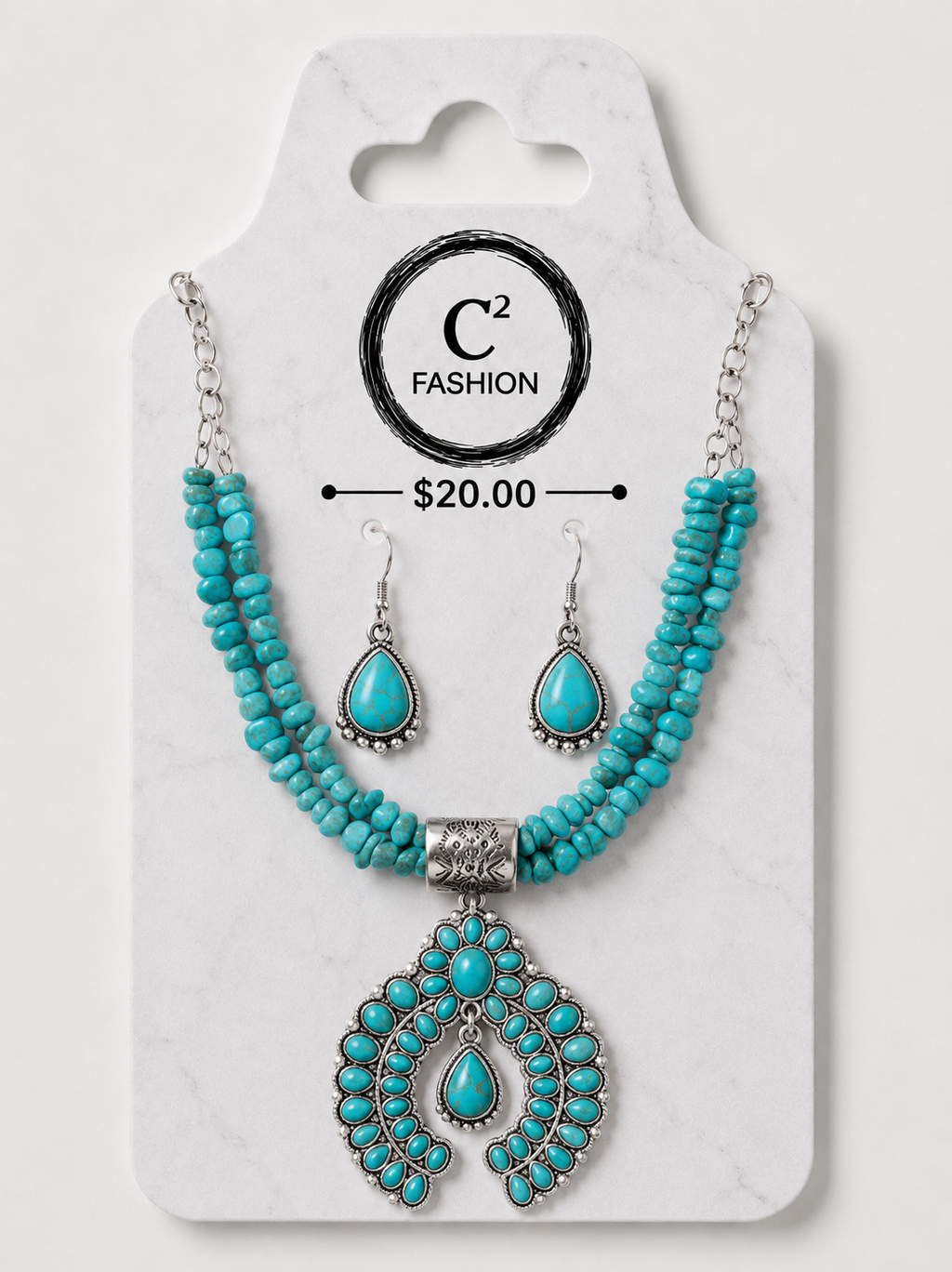 A turquoise and silver jewelry set displayed on a white marble-style card. The set includes a beaded necklace with a large ornate pendant, matching drop earrings, and printed branding for C2 FASHION with a price of $20.