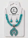 A turquoise and silver jewelry set displayed on a white marble-style card. The set includes a beaded necklace with a large ornate pendant, matching drop earrings, and printed branding for C2 FASHION with a price of $20.