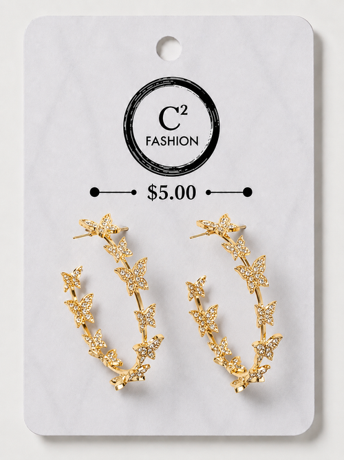 A pair of gold crescent-shaped hoop earrings decorated with small star and leaf motifs, displayed on a white C² FASHION brand card labeled $5.00.