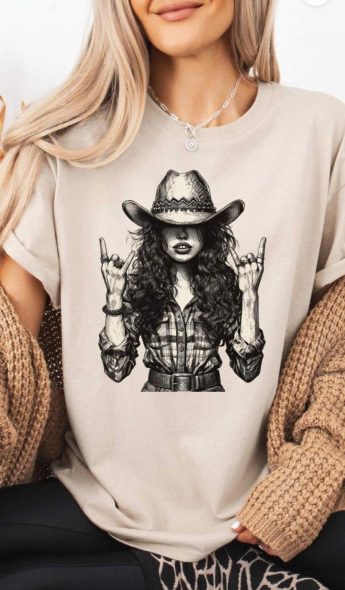 Person wearing a t-shirt with a graphic of a woman in a cowboy hat and plaid shirt.