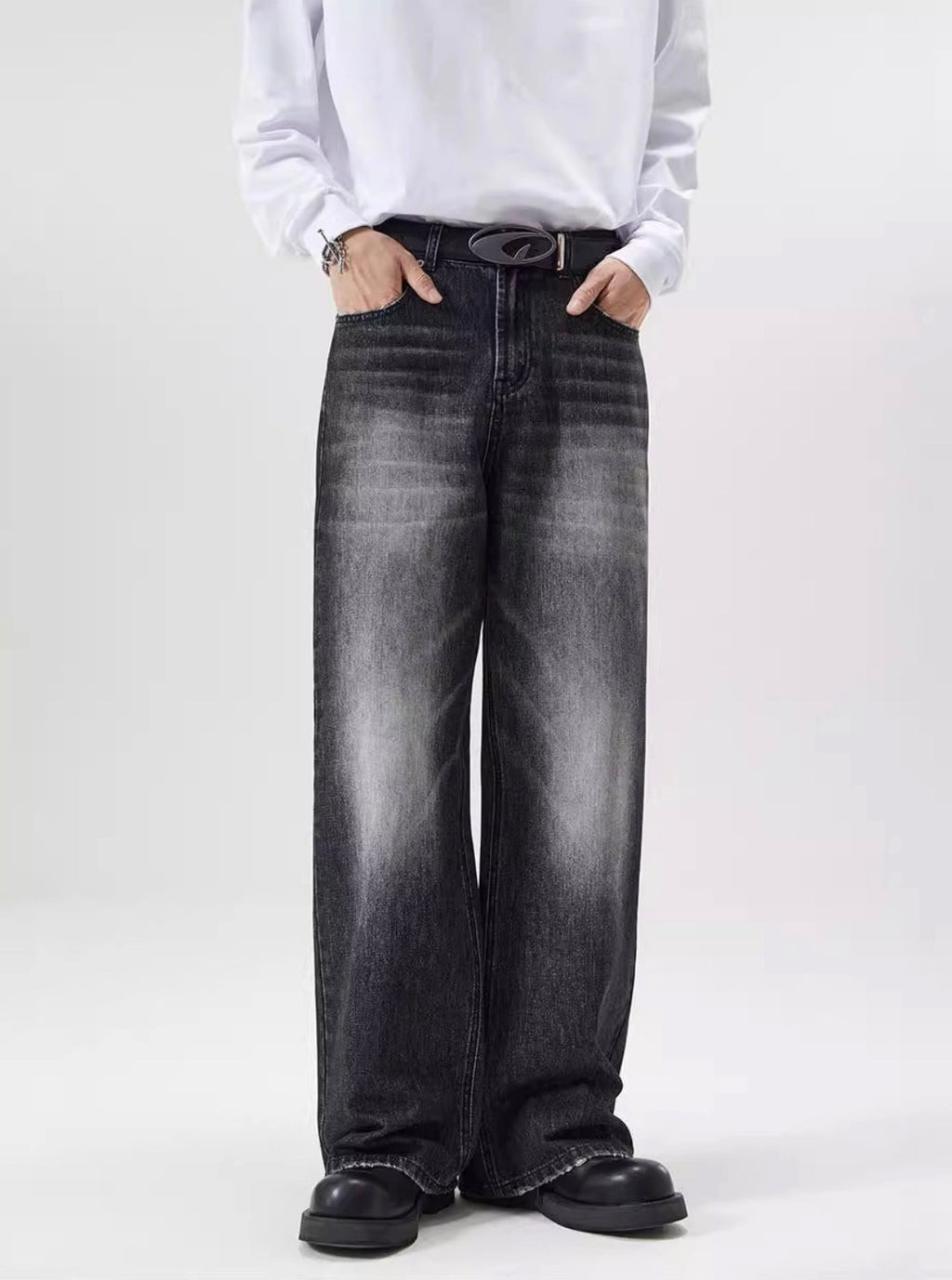 Person wearing black jeans and a white shirt on a white background