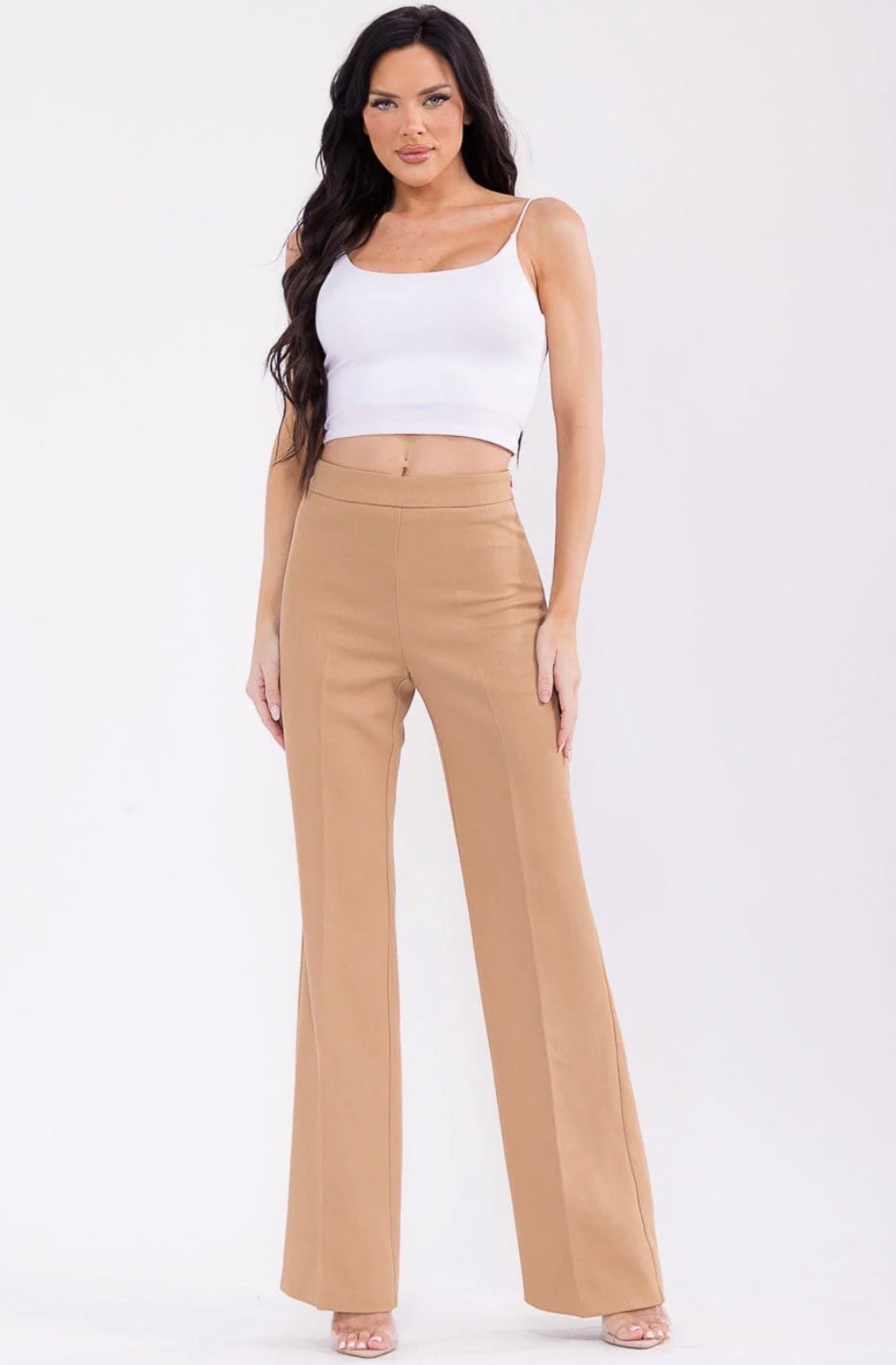Woman wearing a white top and beige high-waisted pants on a white background