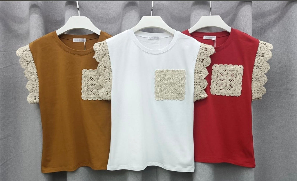 Three tops with lace details on a gray background