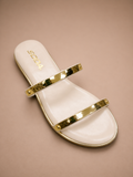 White sandal with gold straps on a beige background