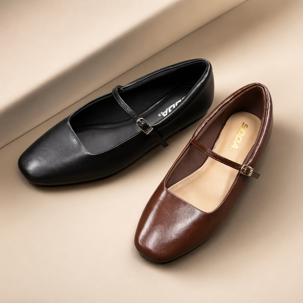 Black and brown flat shoes with a strap on a beige surface