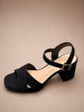 Black sandal with a strap on a beige background