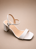 White sandal with a block heel on a beige background