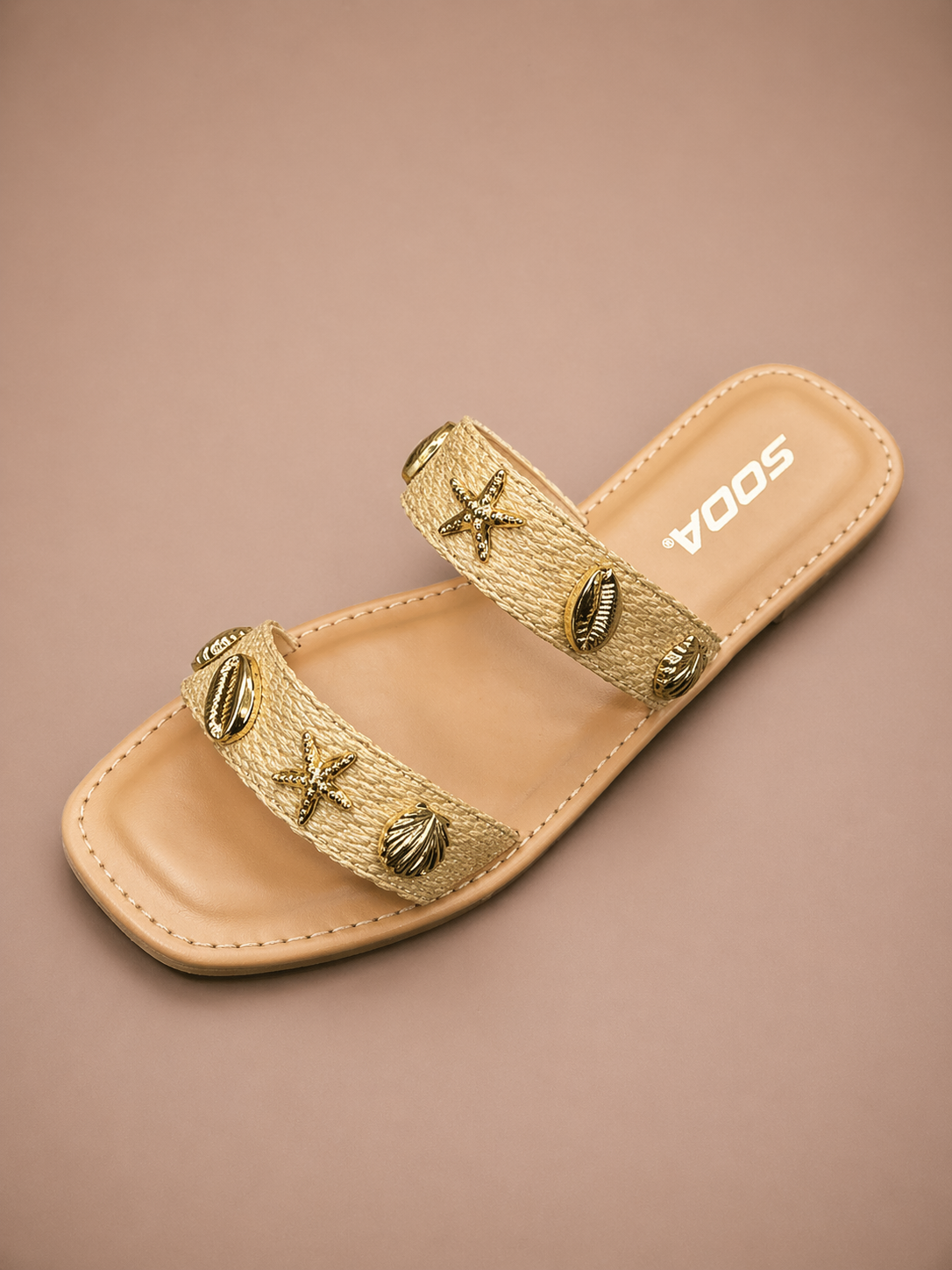 Gold sandal with decorative straps on a beige background
