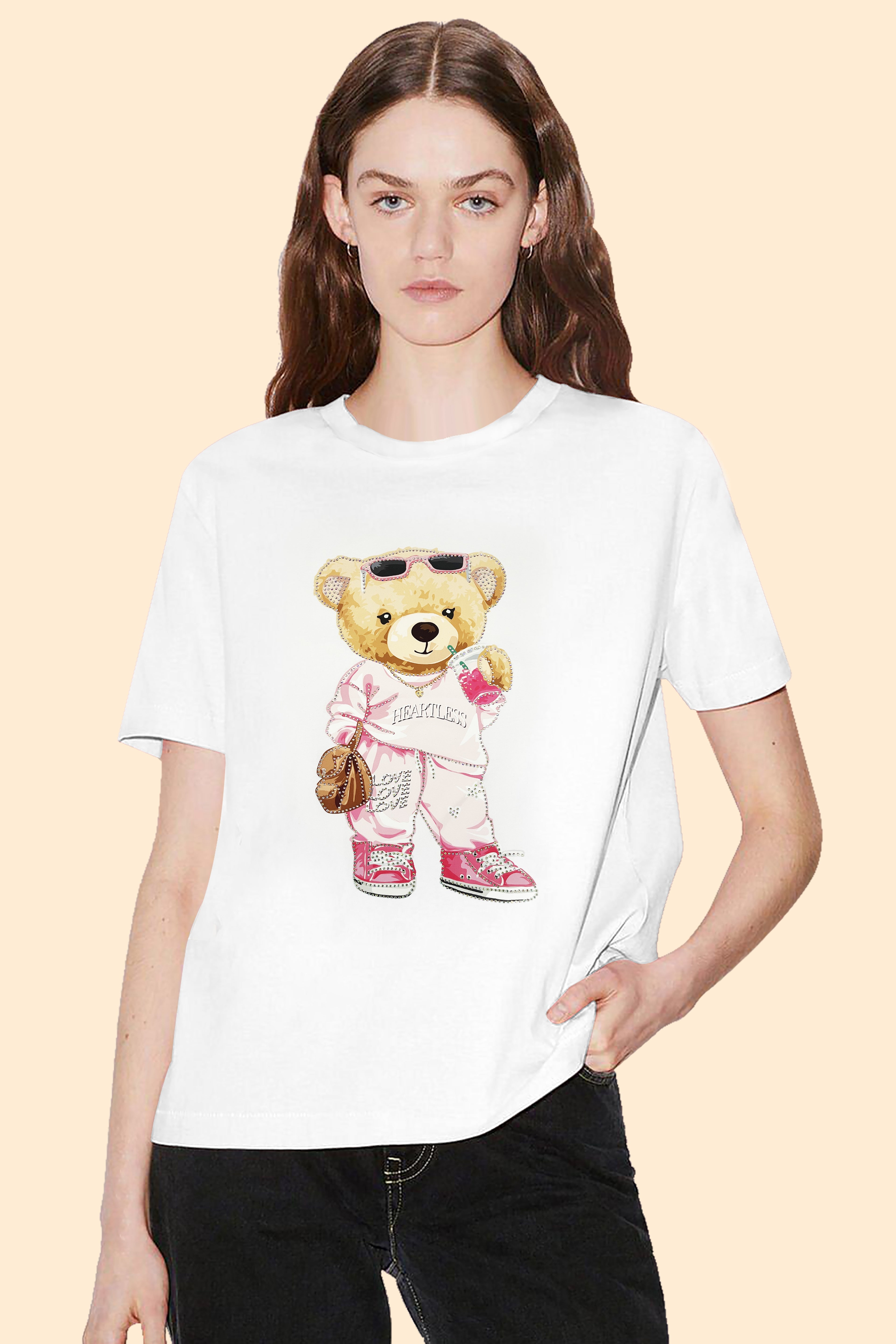 Person wearing a white t-shirt with a teddy bear graphic on a beige background
