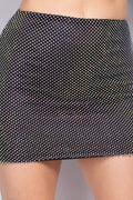 Black polka dot skirt worn by a person on a neutral background